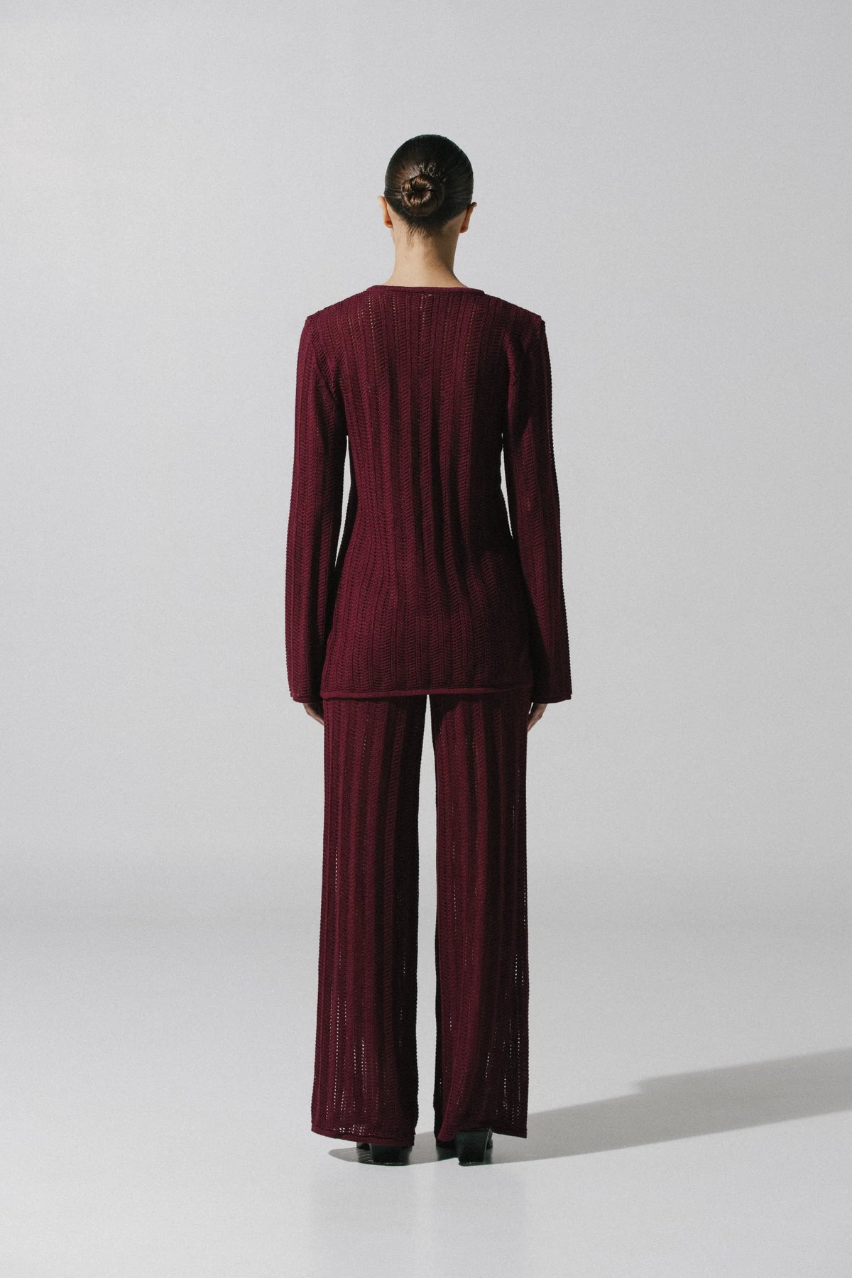 Detail of the Corsica Top in burgundy, Front hardware and Semi-sheer knit fabric.