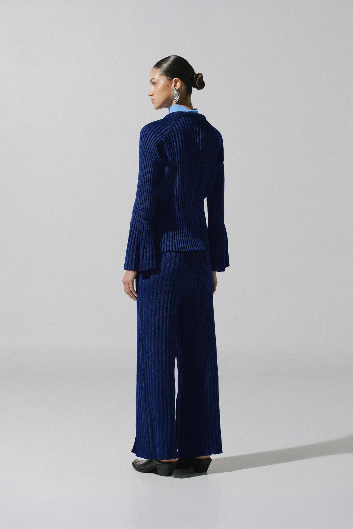 Night blue Lotus Pants in urban outdoor setting, Wide-leg silhouette and Ribbed texture.
