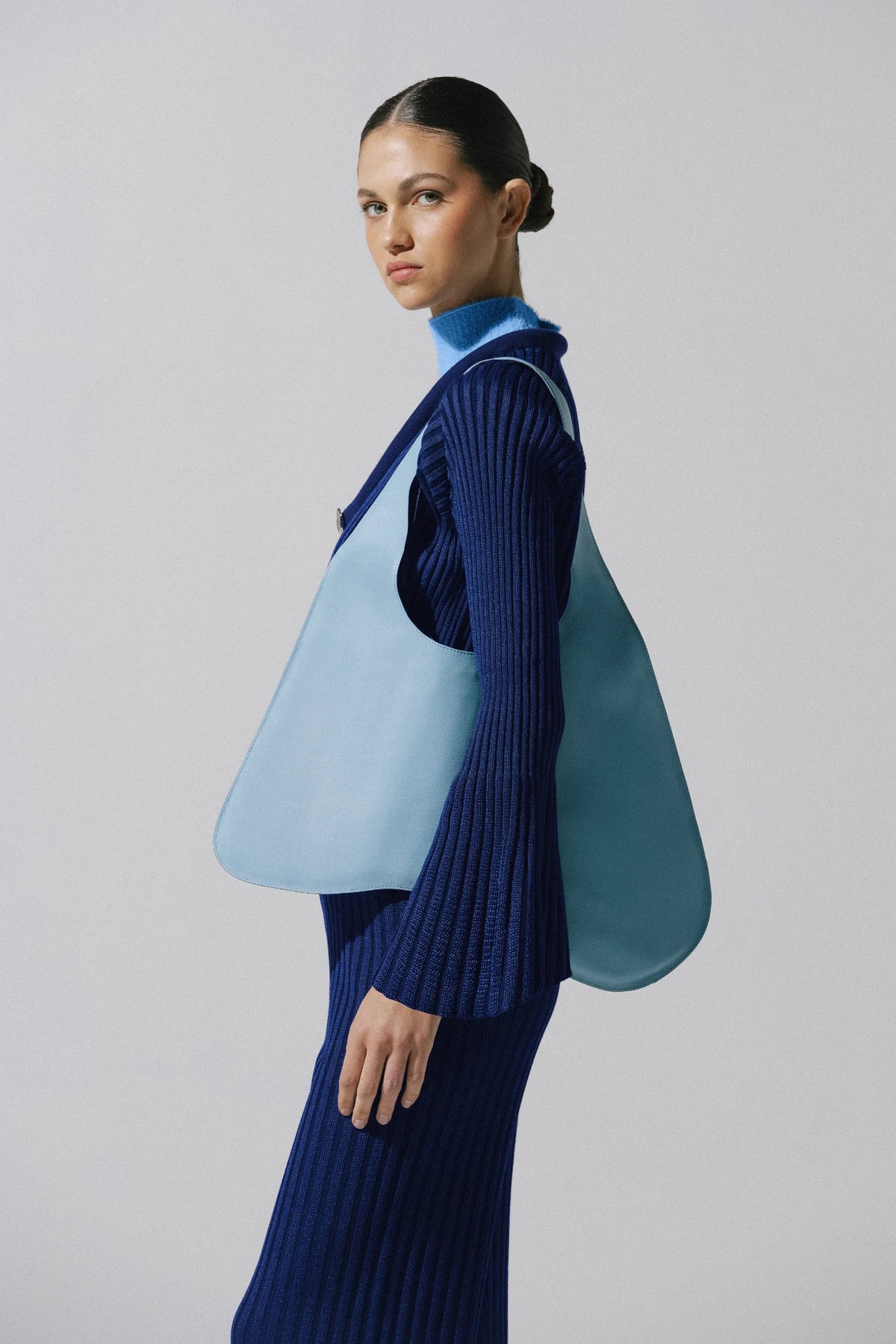 Night blue Lotus Sweater in urban outdoor setting, Wide sleeve and Ribbed texture.