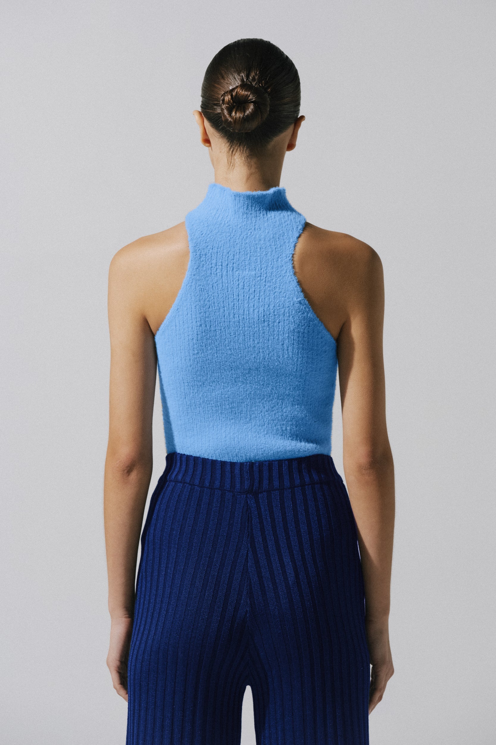 Night blue Lotus Top in urban outdoor setting, Knit fabric and body-hugging silhouette.
