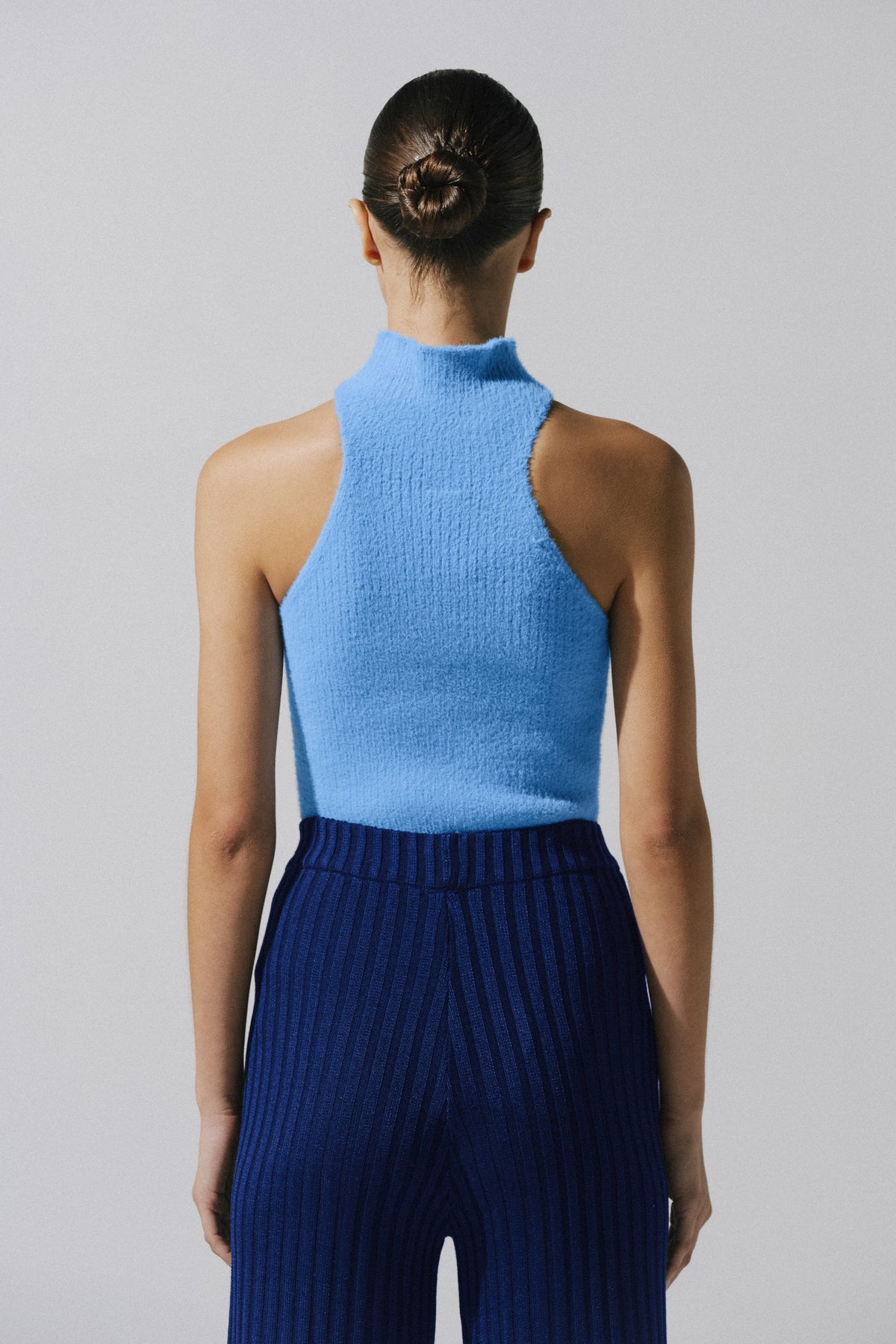 Night blue Lotus Top in urban outdoor setting, Knit fabric and body-hugging silhouette.