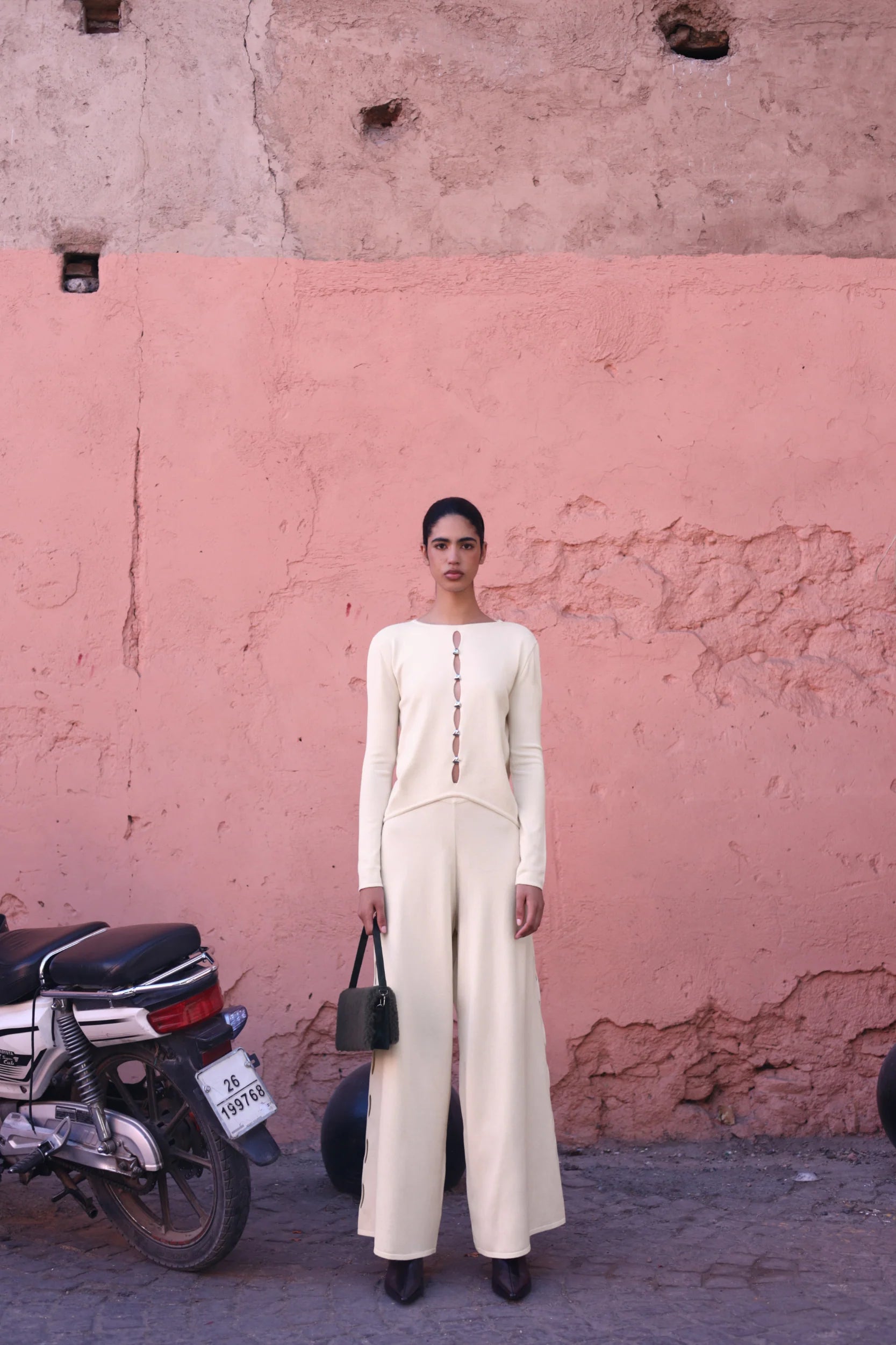 White cream Kyoto Pants in urban outdoor setting, Decorative cutouts and relaxed silhouette.
