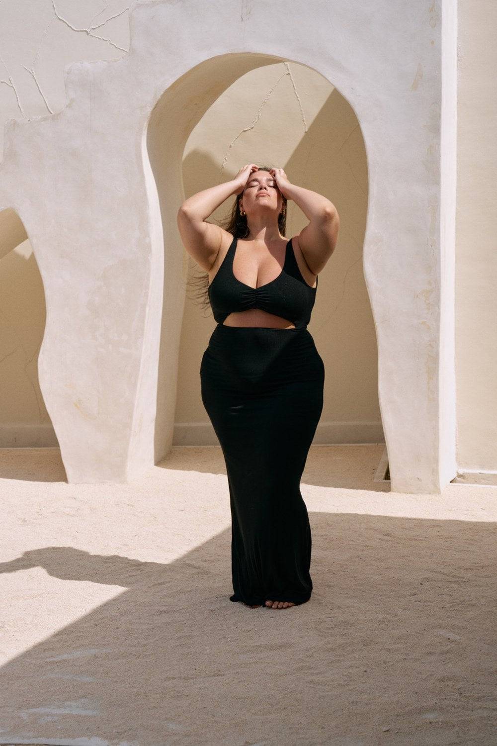 Black Reily Maxi Dress by Riot Lounge, featuring a flowing silhouette and elegant design, displayed on a hanger.