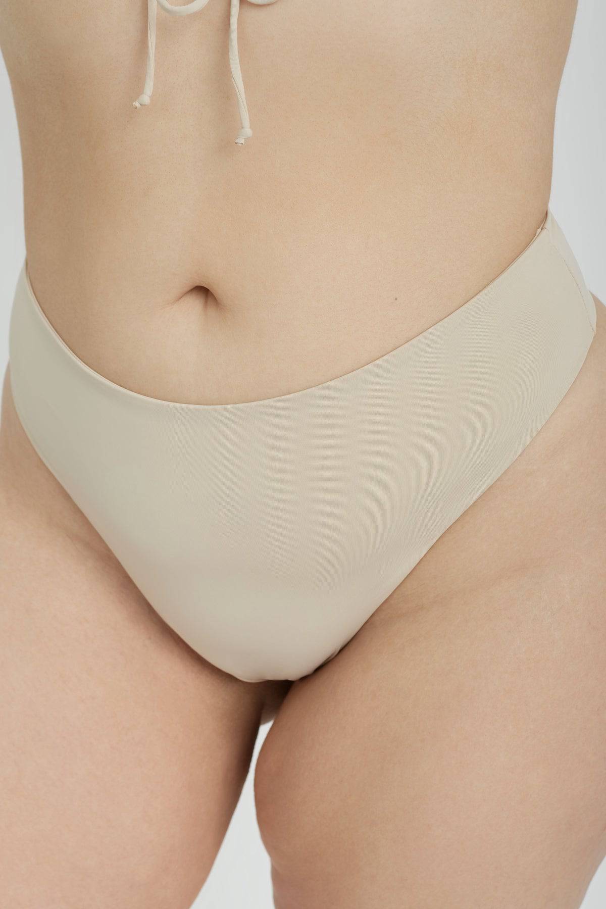Riot Swim Kai high waist coconut bikini bottoms with a smooth fit and tropical-inspired design, shown on a model.