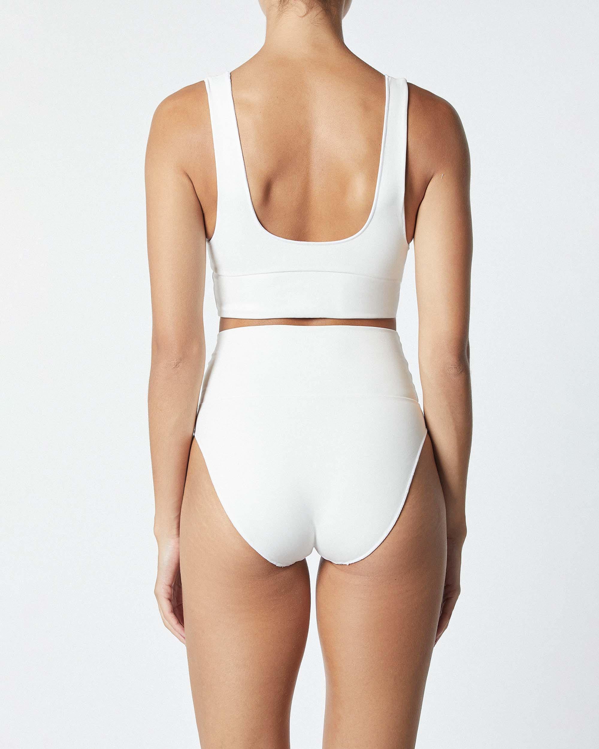 Studio image of model wearing the Contour Crop Top in White, highlighting its thick shoulder straps. 