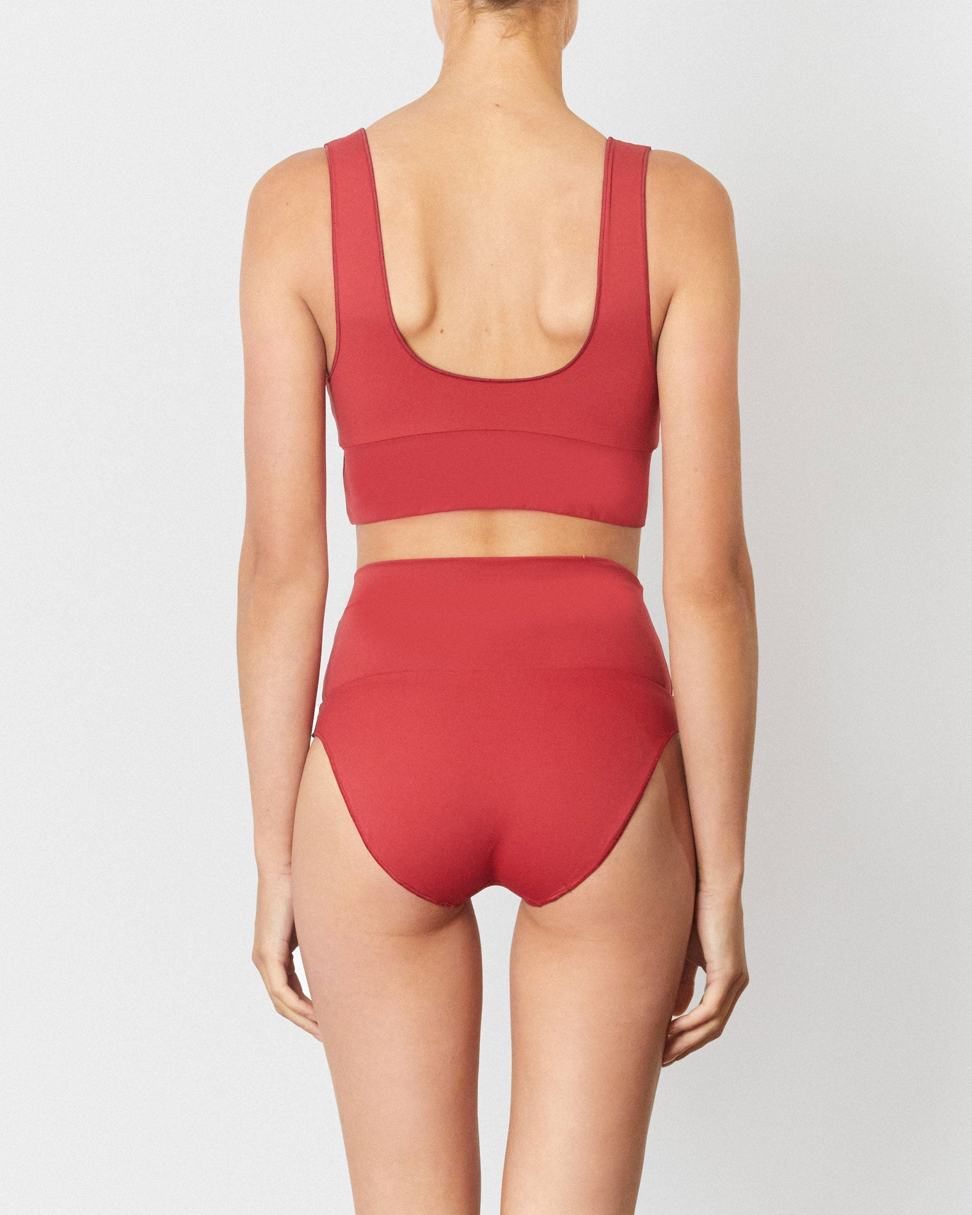 Studio image of model wearing the Contour High Waist Pant in Chilli Red.