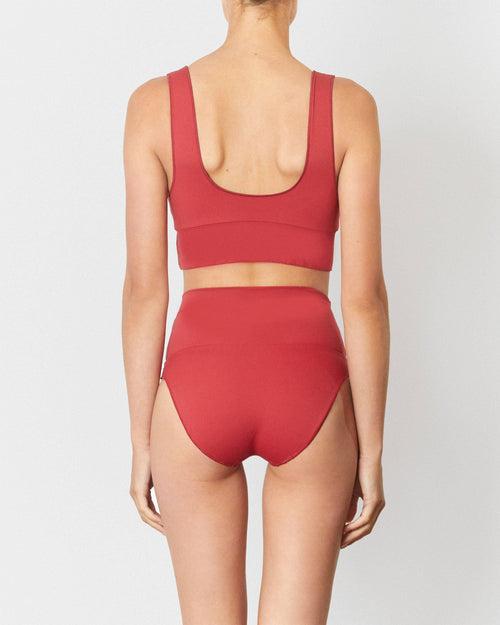 Studio image of model wearing the Contour High Waist Pant in Chilli Red.