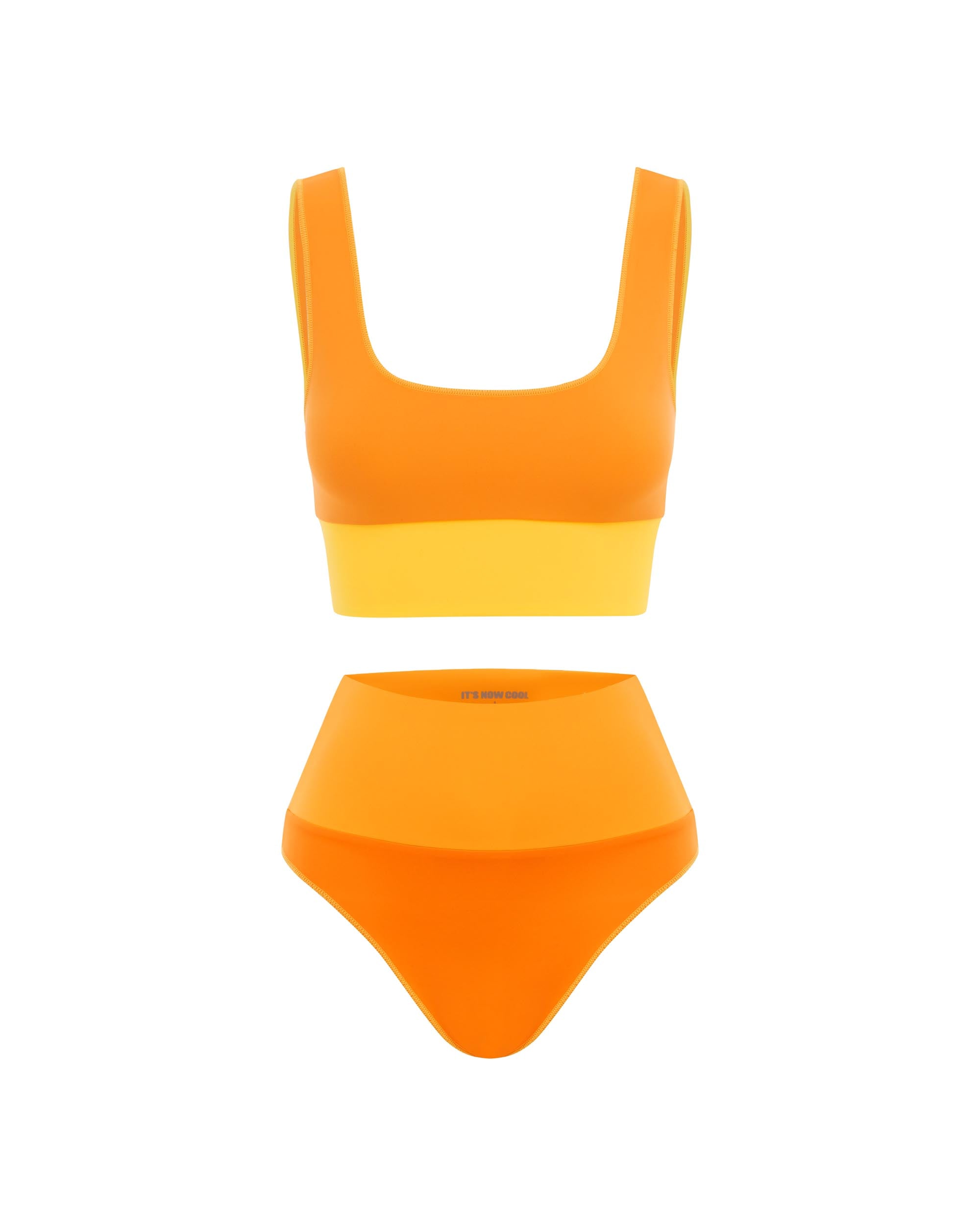 Studio image of the Contour High Waist Pant in Papaya, showcasing its high rise waistband and vibrant orange colors. 