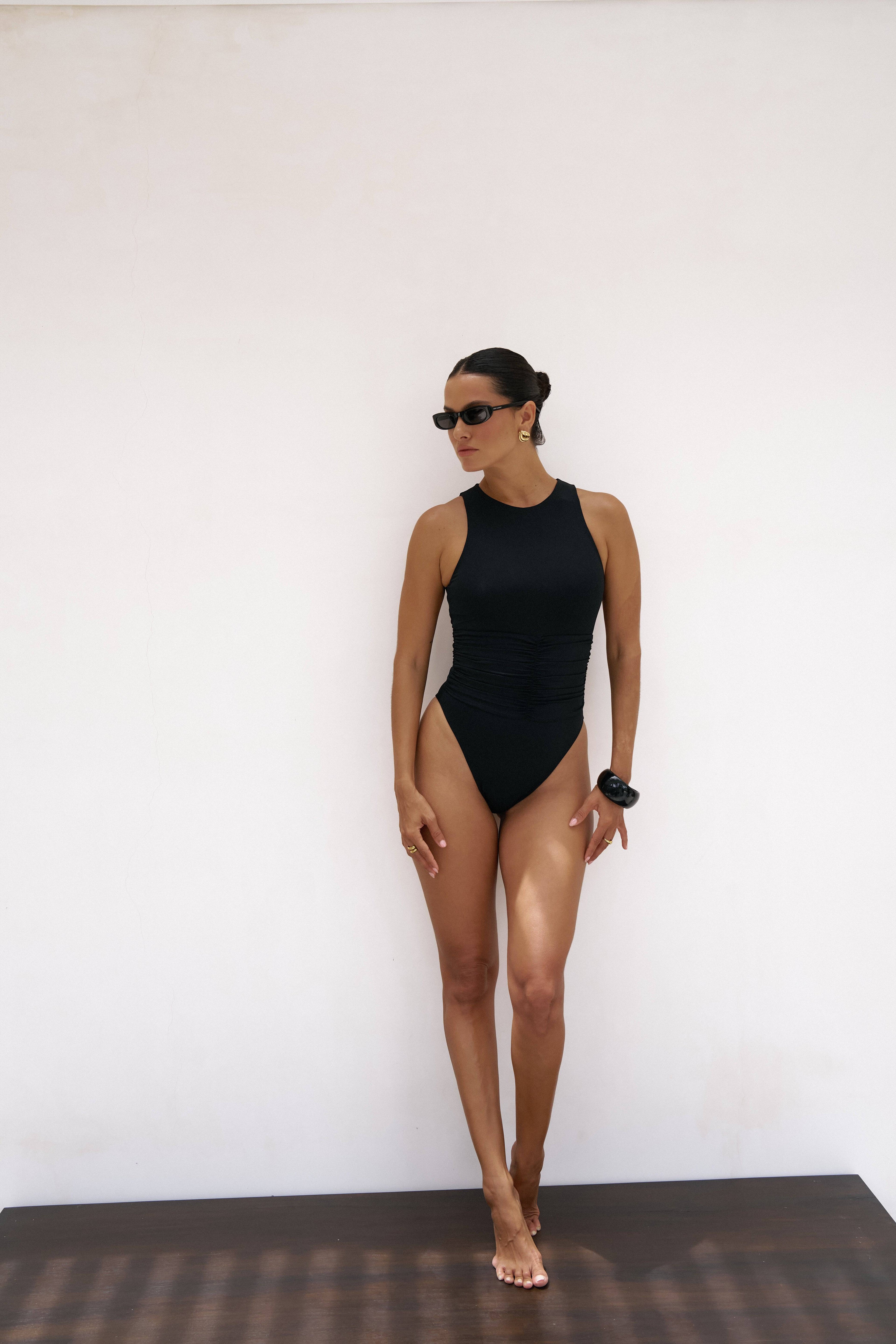 Black RIOT SWIM Jace One Piece Moderate swimsuit displayed on a mannequin, showcasing a sleek, stylish swimwear design.