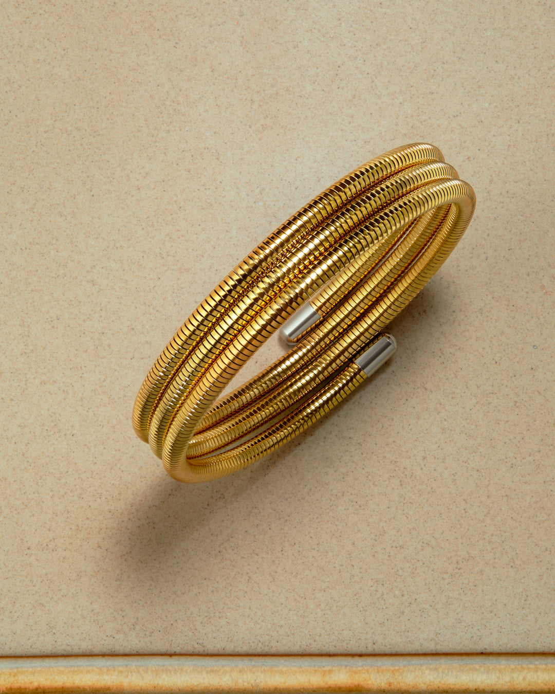 Gold bracelet on a beige background