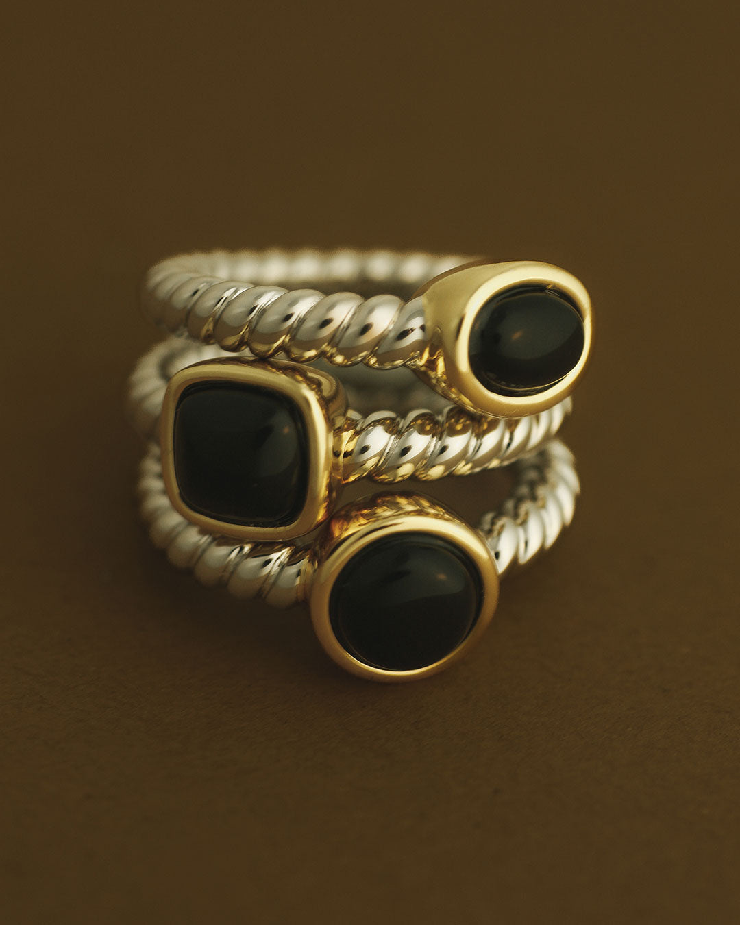 The Luv Aj Midnight Mesa Ring Set stacked on brown background