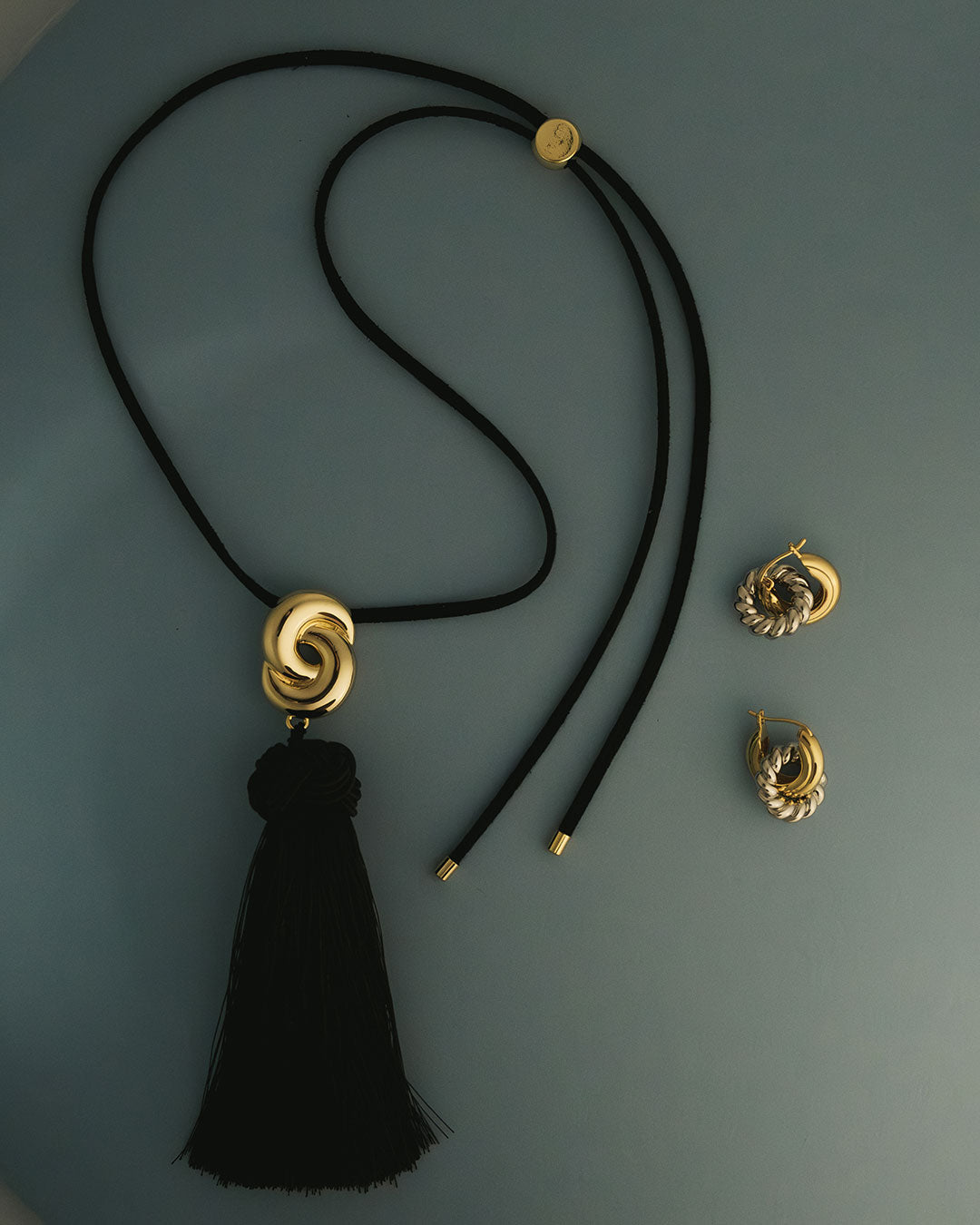 The Luv Aj Solstice Knot Tassle Ring in a flat lay photo