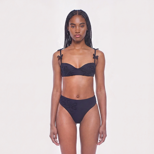 Woman wearing a black bikini set on a white background