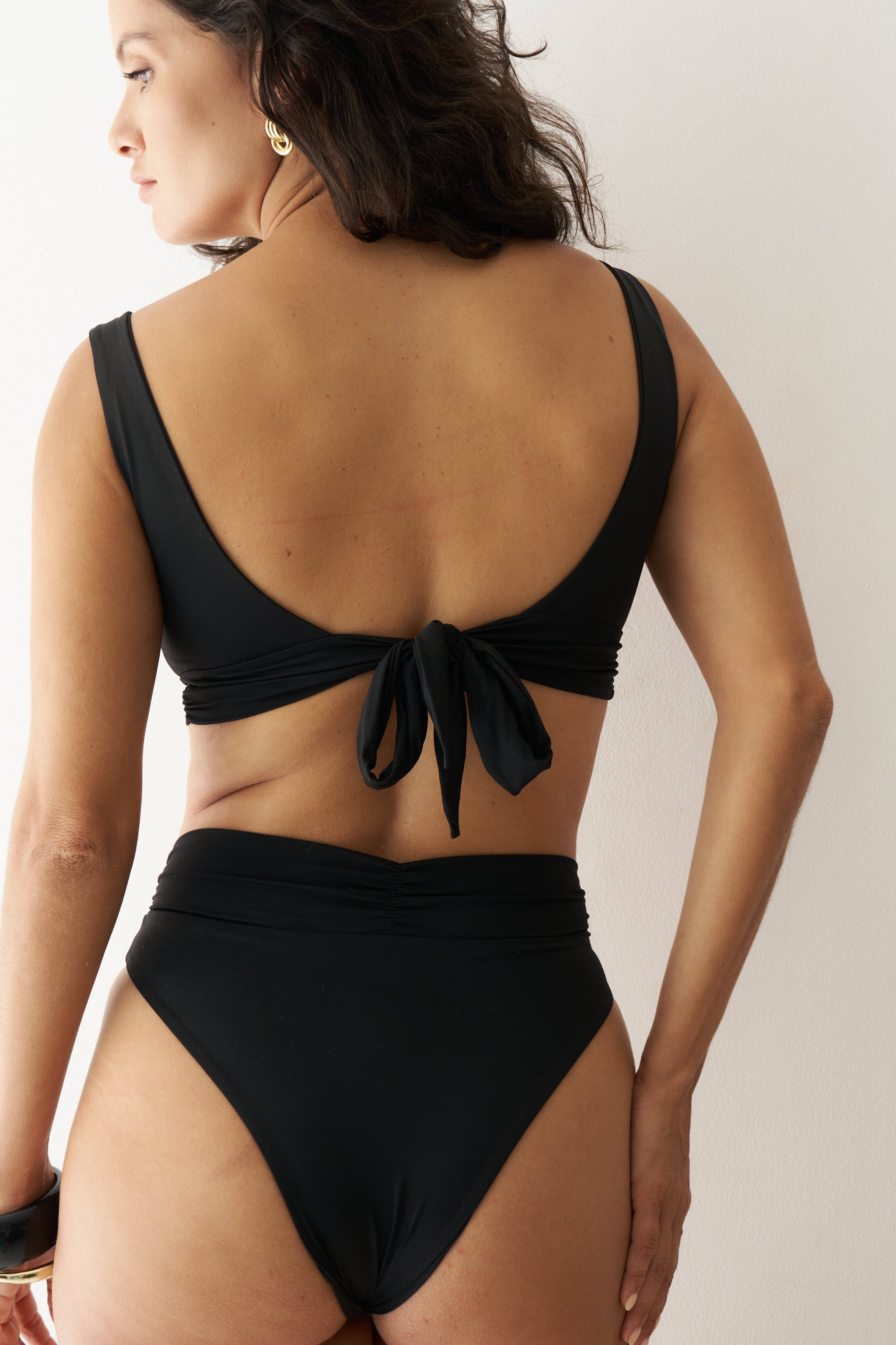 Black RIOT SWIM Pico Top, a stylish swim top shown from the back view with adjustable straps.
