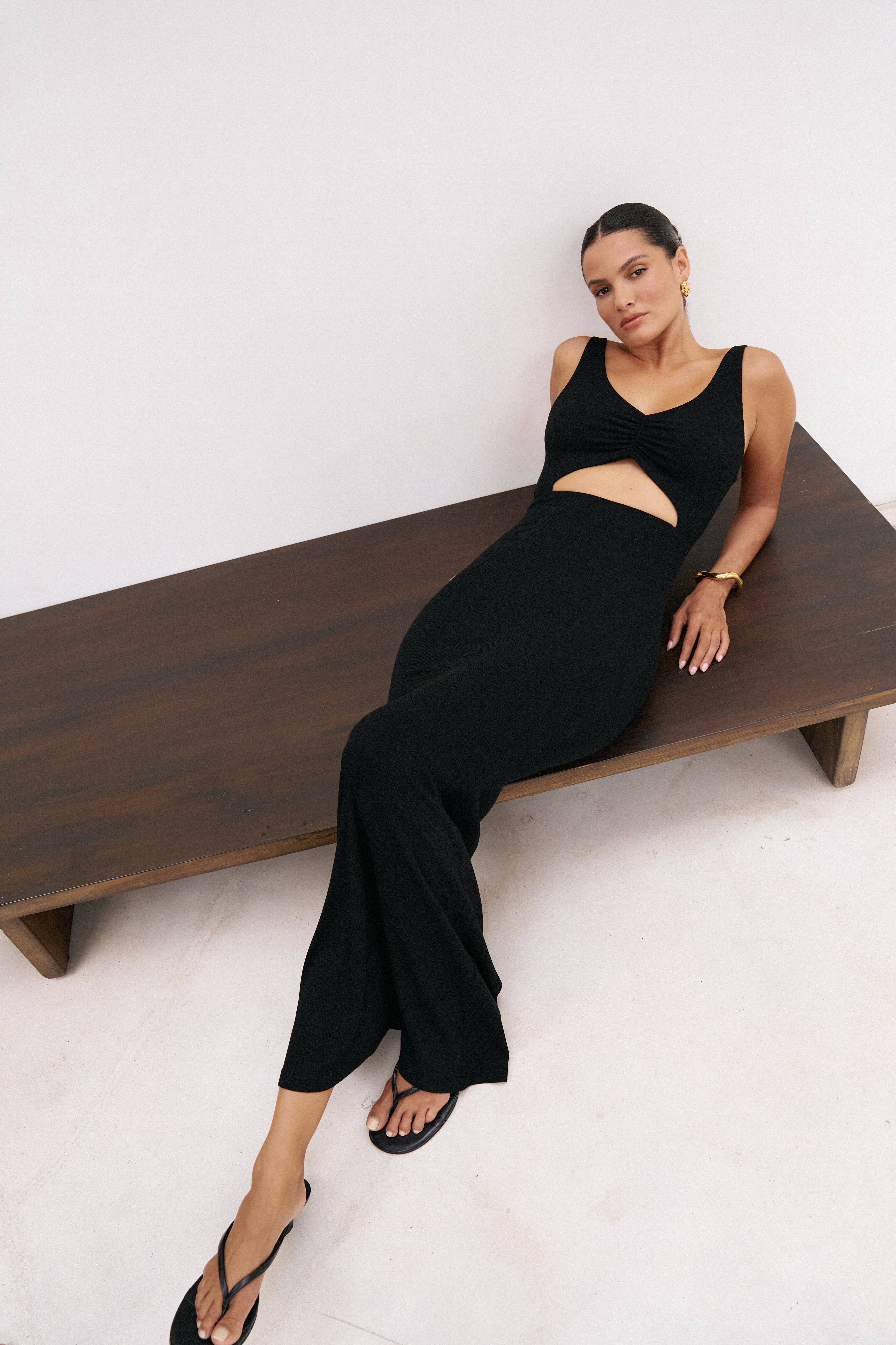 Black Reily Maxi Dress by Riot Lounge displayed on a model, showcasing its flowing silhouette and elegant style.